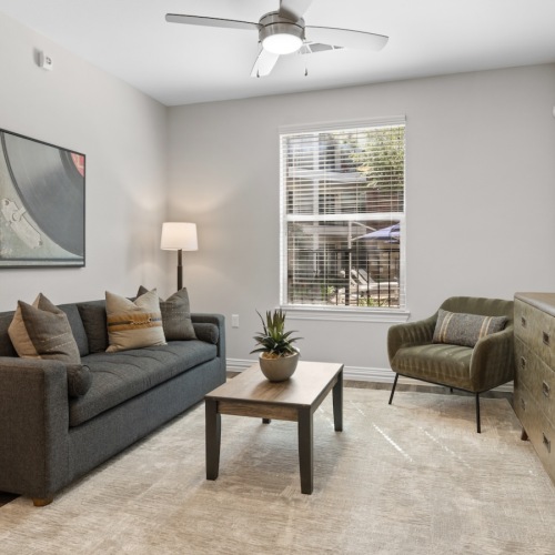 a living room with a couch, chair and tables